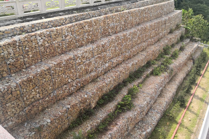 Mit Steinen gefüllte Gabionen als Mauer